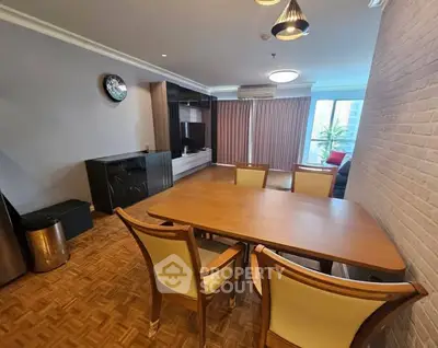 Spacious dining area with elegant wooden table and chairs, featuring parquet flooring and modern lighting.