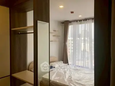 Cozy bedroom with large window and modern furnishings in urban apartment