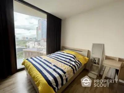 Modern bedroom with large windows offering a panoramic city view, complemented by sleek wooden flooring and contemporary furnishings.