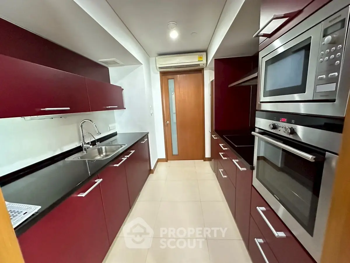 Modern kitchen with sleek red cabinets and built-in appliances