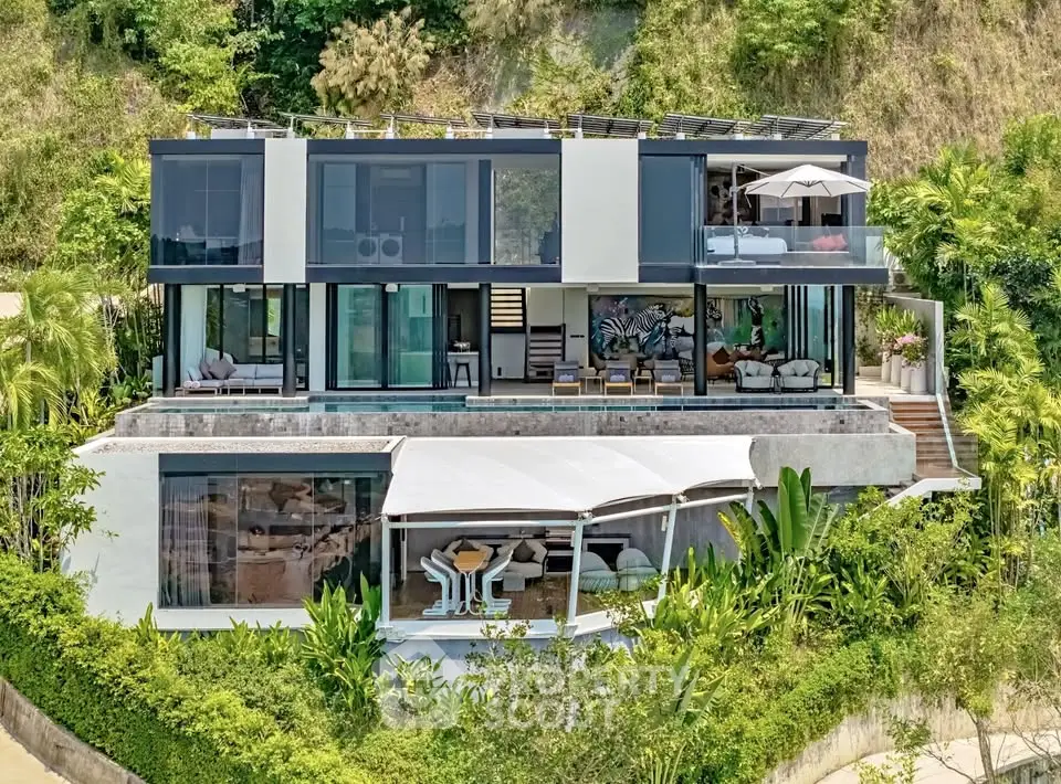 Luxurious modern villa with expansive glass windows and lush greenery, offering stunning hillside views.