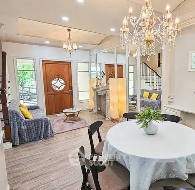 Elegant living room with chandelier, cozy seating, and stylish decor in a modern home.