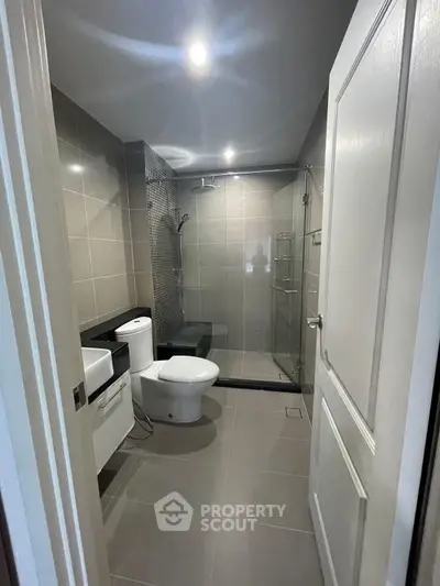 Modern bathroom with sleek design, glass shower enclosure, and elegant fixtures.