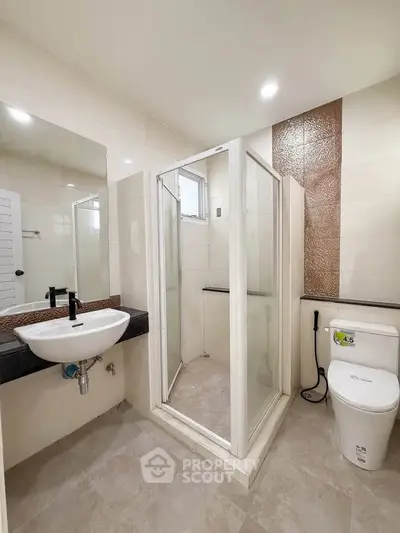 Modern bathroom with glass shower enclosure and sleek fixtures