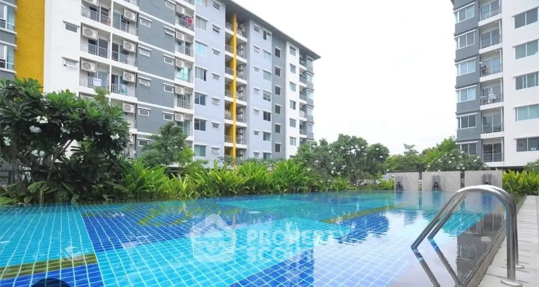 Modern apartment complex with a refreshing outdoor pool and lush greenery.