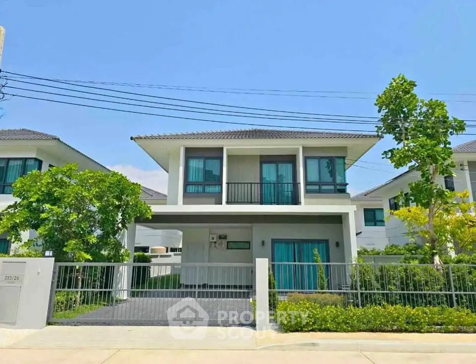 Modern two-story house with a sleek design, large windows, and a well-maintained garden in a suburban neighborhood.
