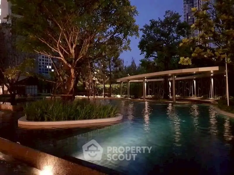 Luxurious residential pool area with ambient evening lighting and lush greenery.