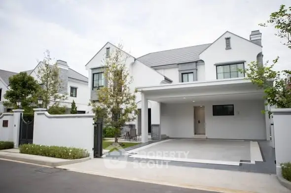 Modern white house with spacious driveway and lush greenery