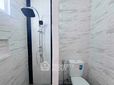 Modern bathroom with sleek shower and white tiled walls, perfect for a contemporary home.