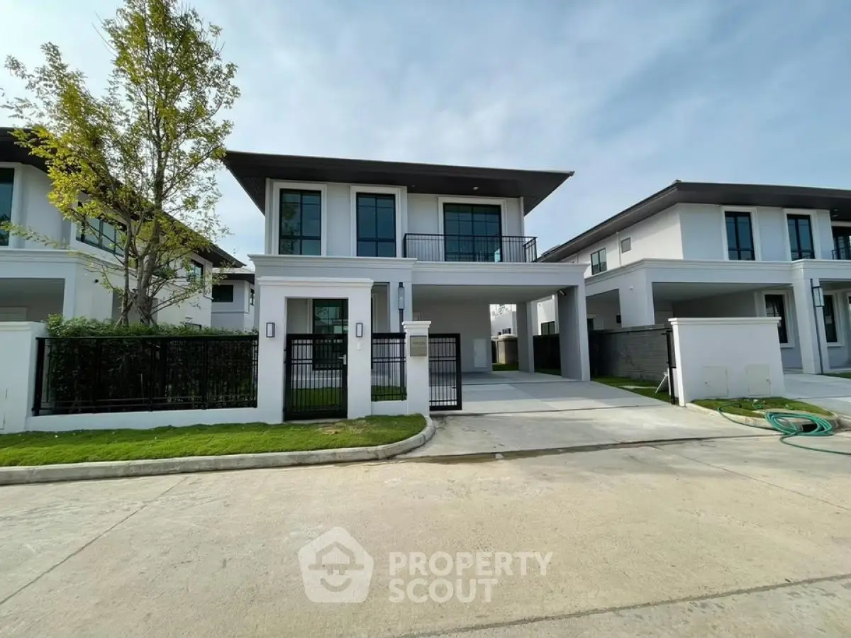 Modern two-story house with spacious driveway and manicured lawn in a serene neighborhood.