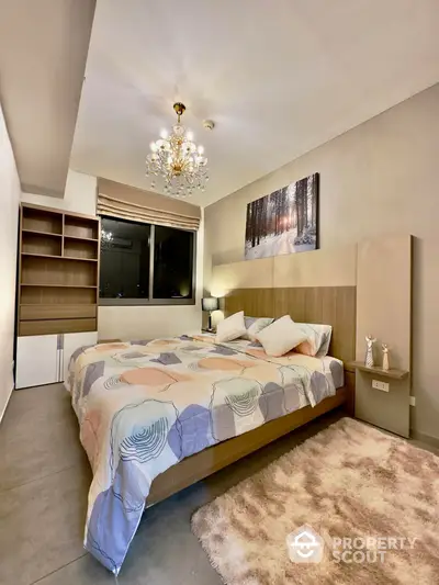 Luxurious bedroom with elegant chandelier lighting, plush bedding, and modern furnishings, perfect for a restful retreat in a high-end home.