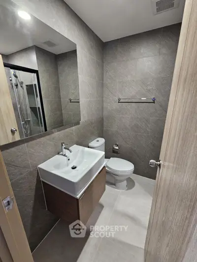 Modern bathroom with sleek fixtures and neutral tiles in contemporary apartment