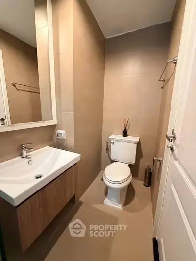 Modern bathroom with sleek fixtures and neutral tones, featuring a compact design for efficient space use.