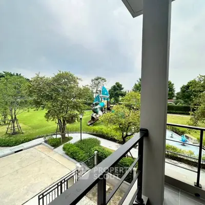 Spacious balcony overlooking lush green park with playground