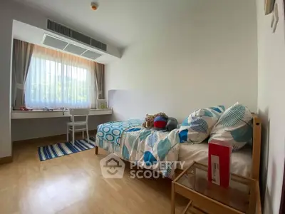 Bright and cozy bedroom with modern decor and large window view.