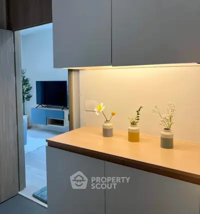 Modern living room with stylish decor and TV unit, featuring elegant lighting and minimalist design.