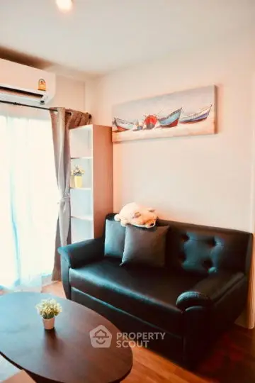 Cozy living room with black leather sofa and nautical decor, perfect for relaxation.