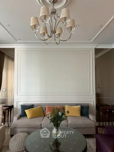 Elegant living room with plush sofa, stylish chandelier, and chic decor accents.