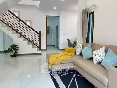 Spacious modern living room with stylish staircase and cozy seating area.