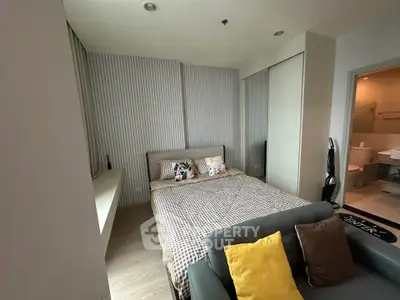 Cozy bedroom with modern decor and ensuite bathroom in a stylish apartment.