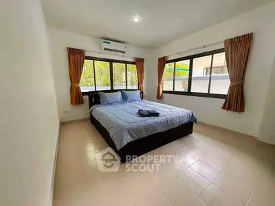Spacious bedroom with large windows and modern air conditioning unit