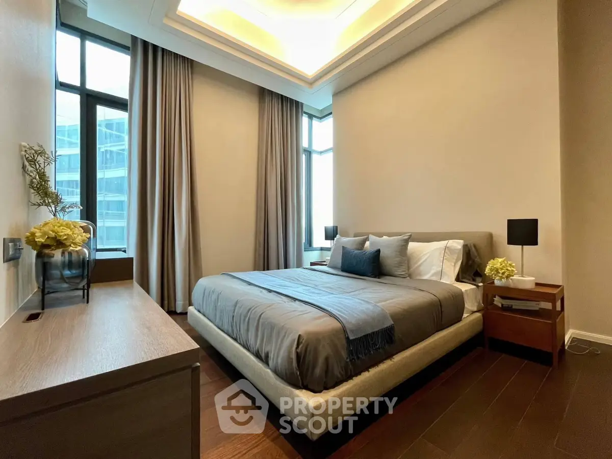 Luxurious modern bedroom with elegant decor and large windows in a high-rise apartment.