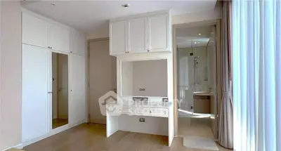 Bright bedroom with built-in wardrobe and vanity, featuring a modern ensuite bathroom.