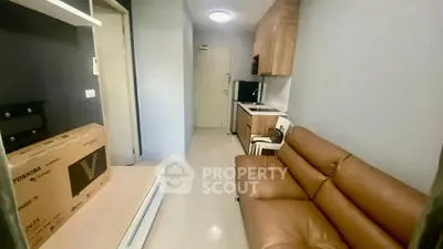 Cozy studio apartment with modern kitchen and leather sofa, perfect for urban living.