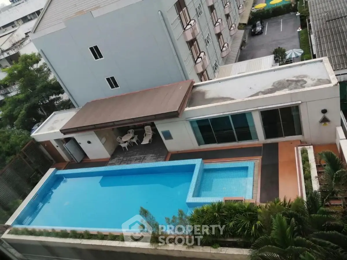 Modern apartment complex with a stunning rooftop pool and lush greenery, offering a luxurious urban lifestyle.