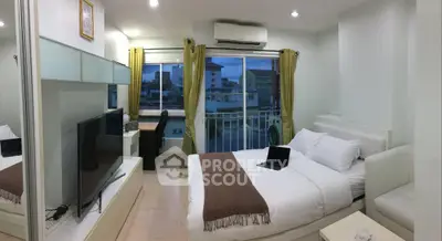 Modern bedroom with city view, featuring a cozy bed, large TV, and workspace.