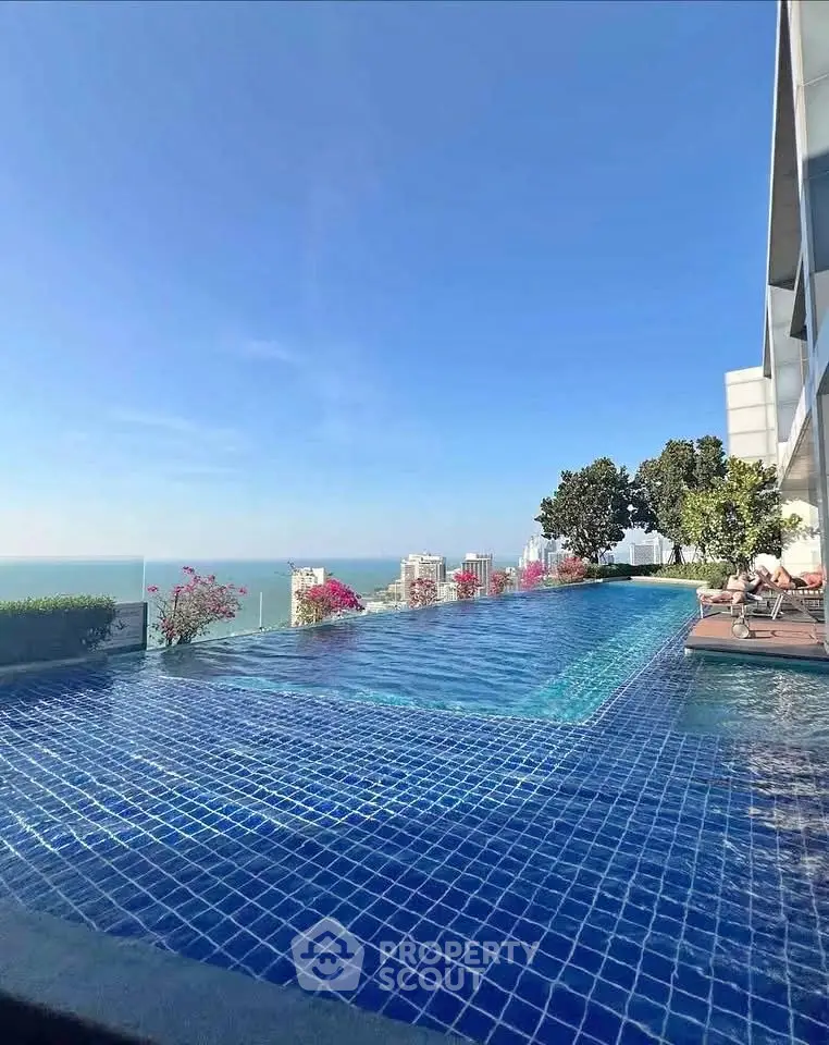 Stunning rooftop infinity pool with breathtaking ocean view and city skyline.