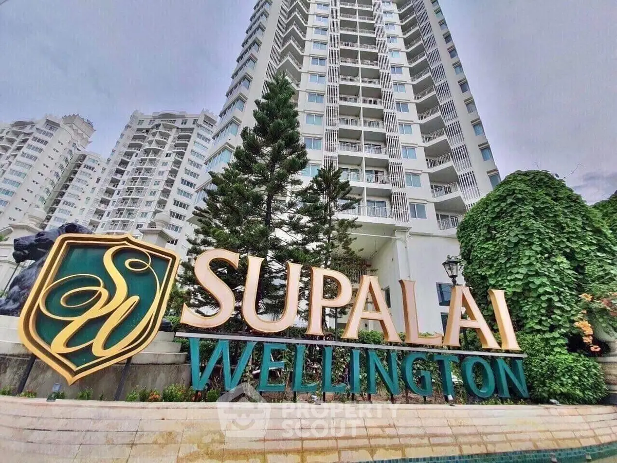 Luxurious high-rise Supalai Wellington building exterior with lush greenery and elegant signage.