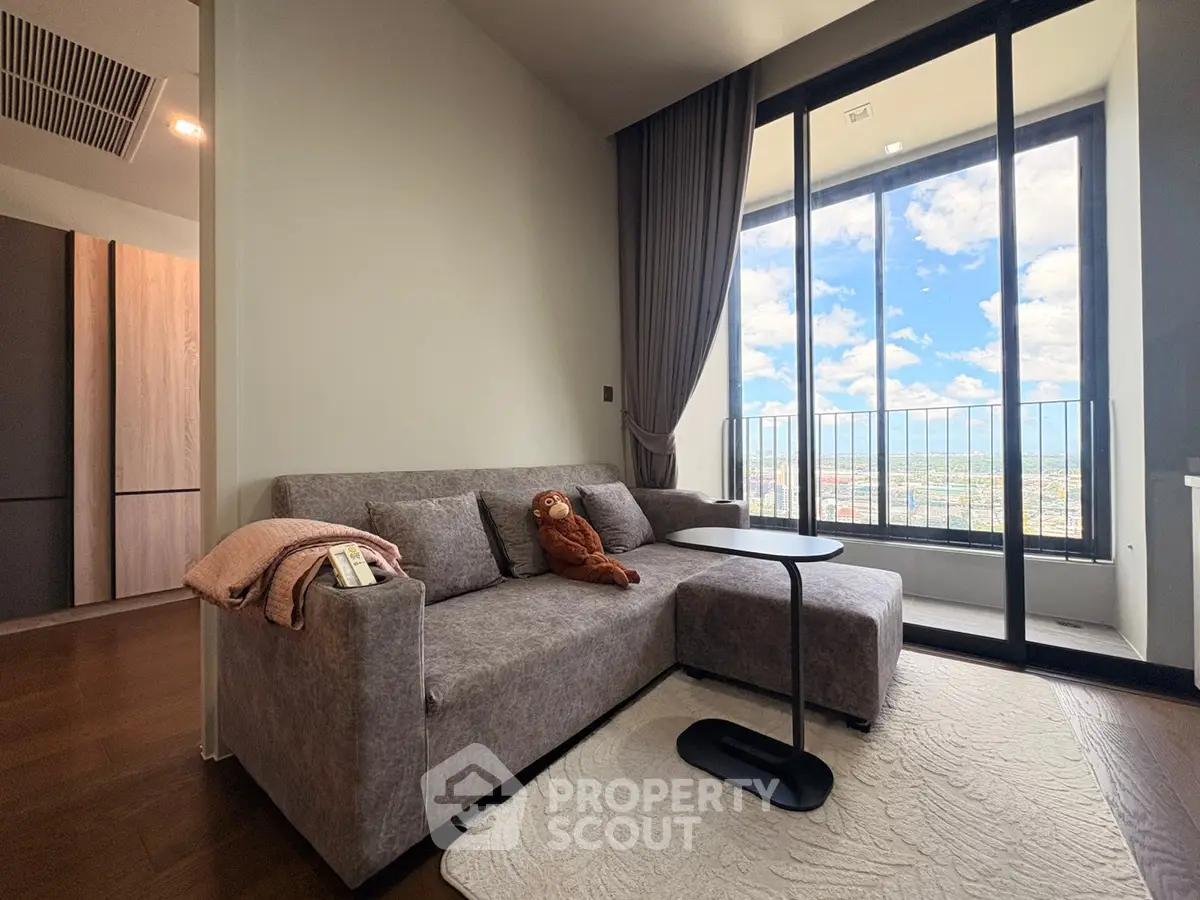 Modern living room with cozy sofa and stunning balcony view in high-rise apartment.