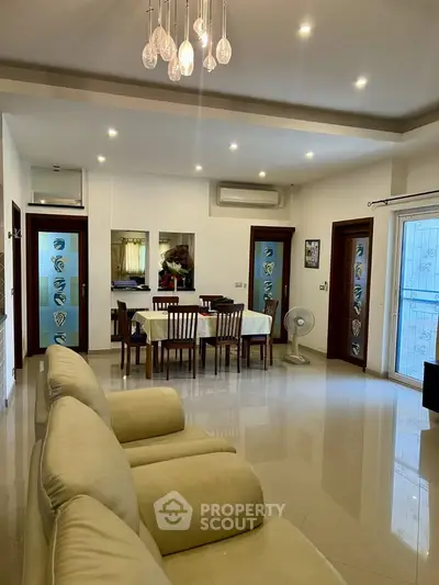 Spacious living room with modern dining area and elegant lighting in a contemporary apartment.