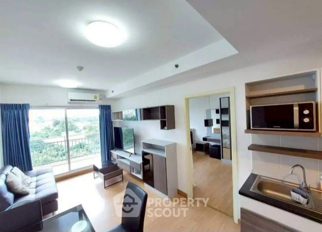 Modern living room with open kitchen and balcony view