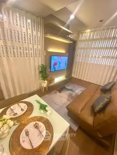 Modern living room with stylish decor, leather sofa, and wall-mounted TV in a cozy apartment setting.