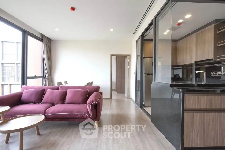 Modern living room with open kitchen and stylish furniture in a bright apartment.