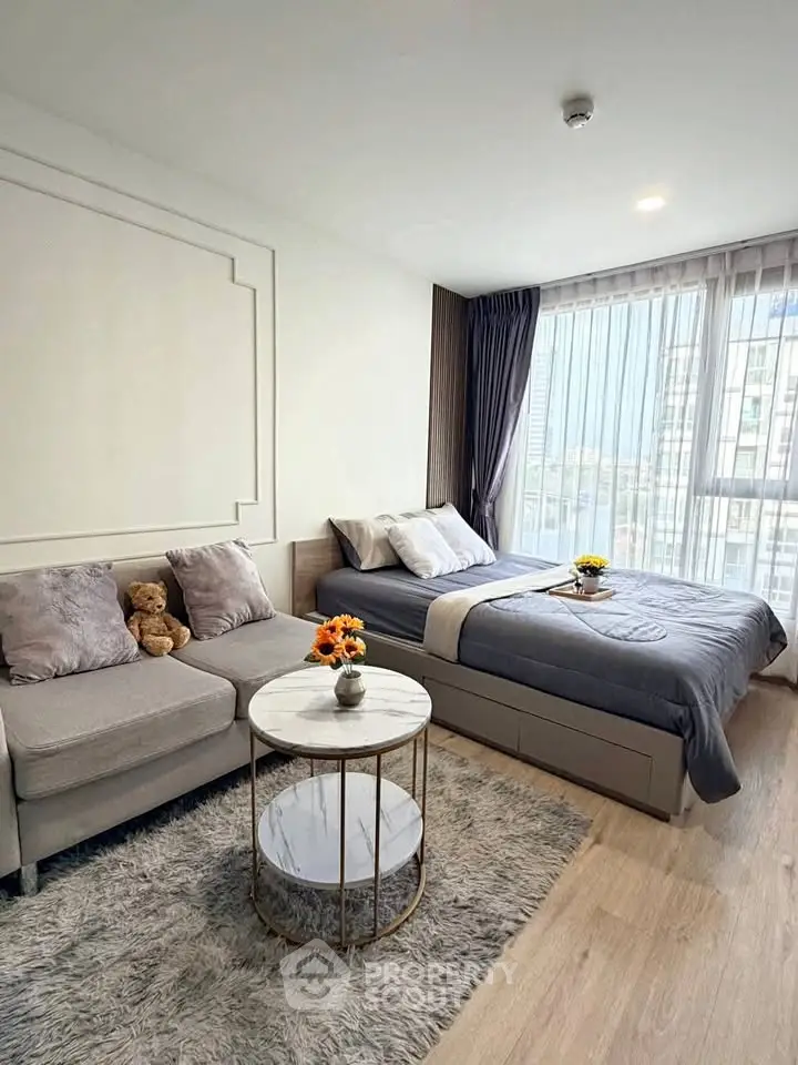 Modern bedroom with cozy seating area and large window view