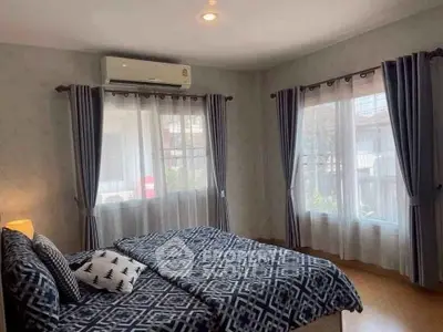 Spacious bedroom with large windows and modern decor, featuring an air conditioning unit for comfort.