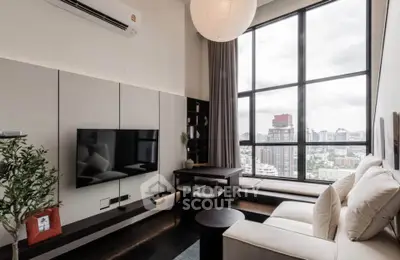 Modern living room with large windows and city view, featuring stylish furniture and decor.