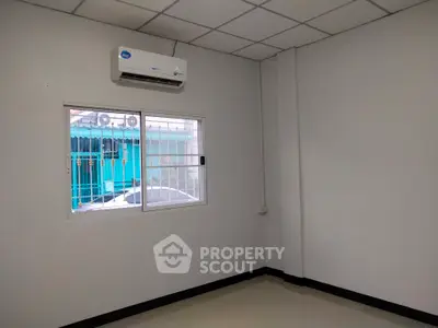 Spacious room with air conditioning and window view, ideal for customization.