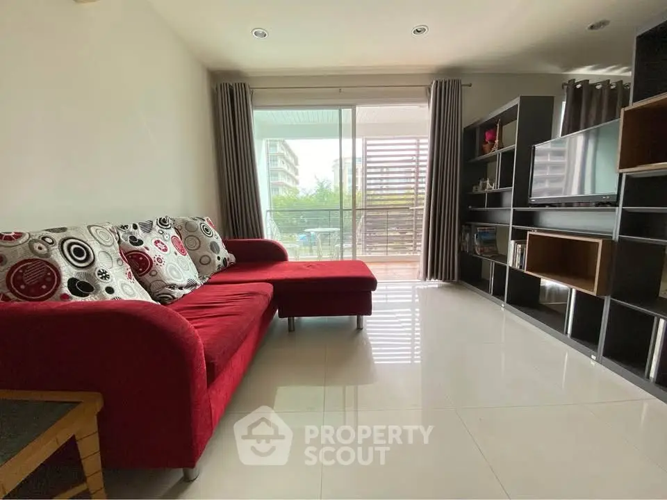 Modern living room with red sofa and balcony view