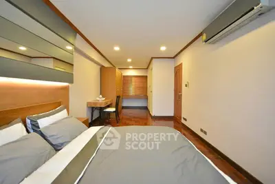 Spacious bedroom with modern decor and air conditioning in a stylish apartment.
