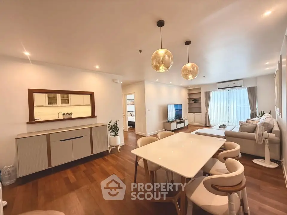 Spacious modern living room with elegant dining area and stylish lighting in a cozy apartment.
