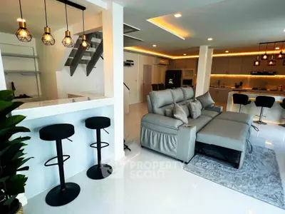 Modern open-plan living room with stylish kitchen and elegant lighting