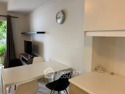 Modern dining area with TV and minimalist decor in a bright apartment