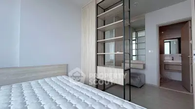 Modern bedroom with minimalist design and ensuite bathroom in a stylish apartment.