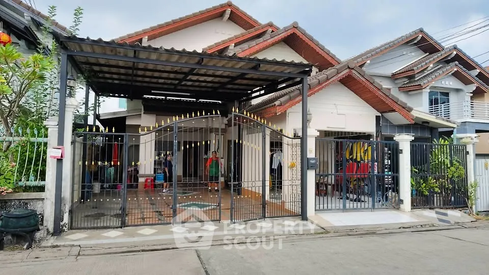 Charming suburban house with gated entrance and tiled patio, perfect for family living.