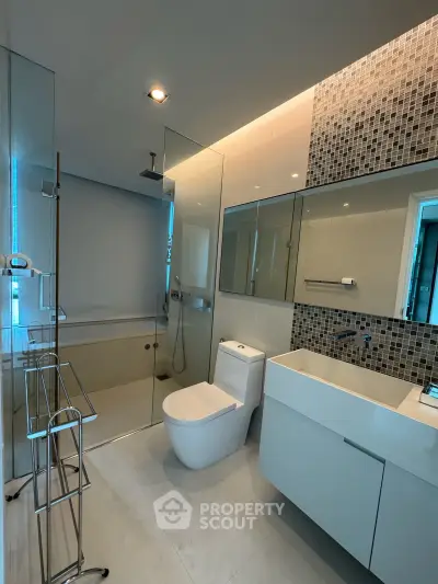 Modern bathroom with sleek design, glass shower, and stylish fixtures in a contemporary home.