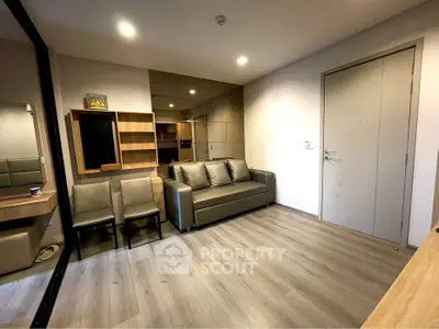 Modern living room with sleek furniture and wooden flooring in a stylish apartment.